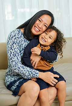dark haired mother holding child with curly hair