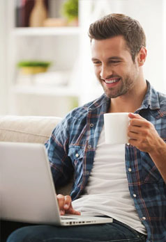 man drinking coffee while using laptop